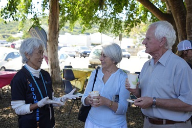 Three people outdoors under a tree