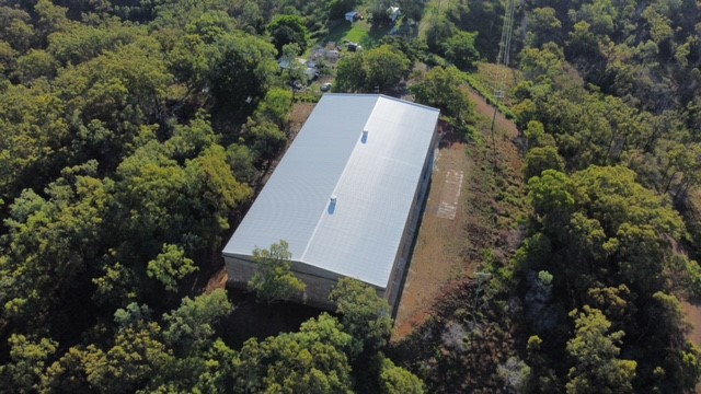 Aerial view of Mt Charlton Reservoir’s new roof, surrounded by dense green vegetation.
