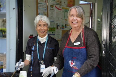 Two volunteers wearing gloves stand side by side